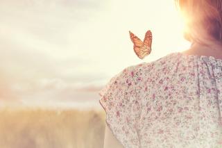 Žena s motýlem na rameni.